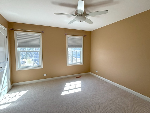 unfurnished room with visible vents, baseboards, and light carpet