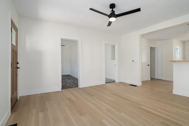 unfurnished room with visible vents, light wood-style flooring, baseboards, and a ceiling fan