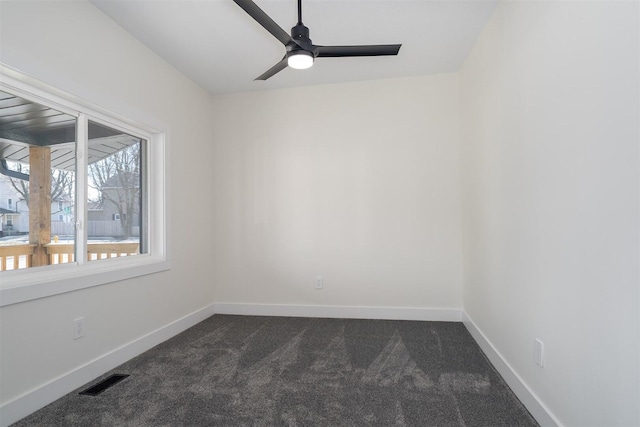 unfurnished room featuring visible vents, dark carpet, baseboards, and ceiling fan