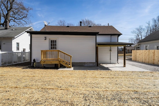 back of house with a patio area, a shingled roof, and fence