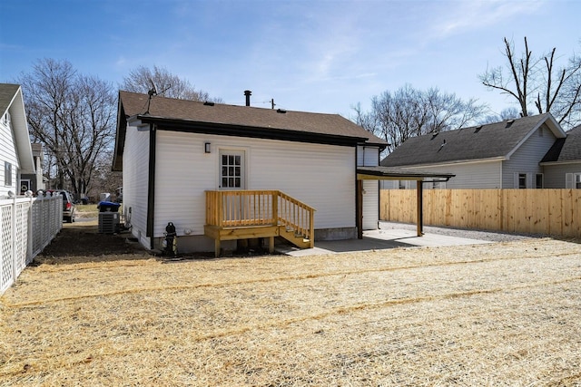 rear view of house with a patio area, central AC unit, and fence