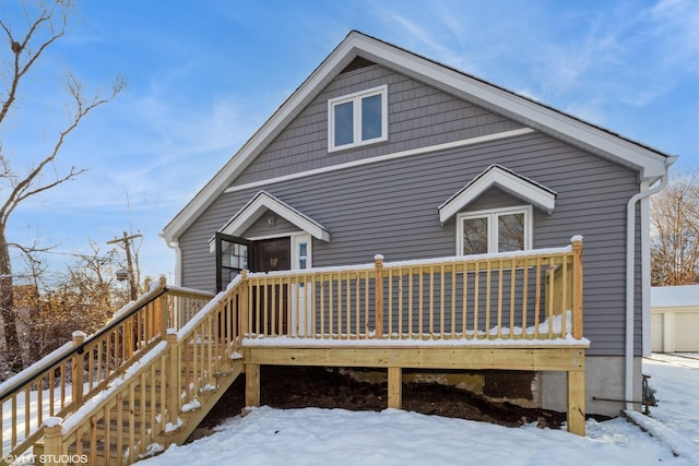 snow covered rear of property featuring a deck and stairway