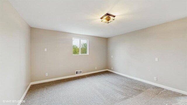carpeted empty room featuring baseboards