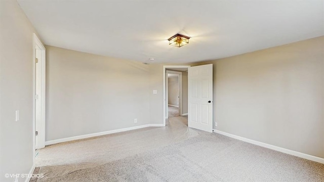 spare room with light colored carpet and baseboards