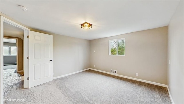 empty room featuring carpet flooring and baseboards