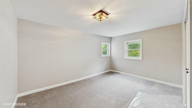 carpeted spare room featuring baseboards
