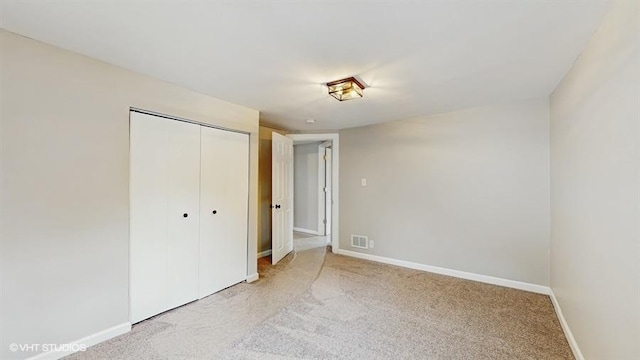unfurnished bedroom featuring light carpet and baseboards