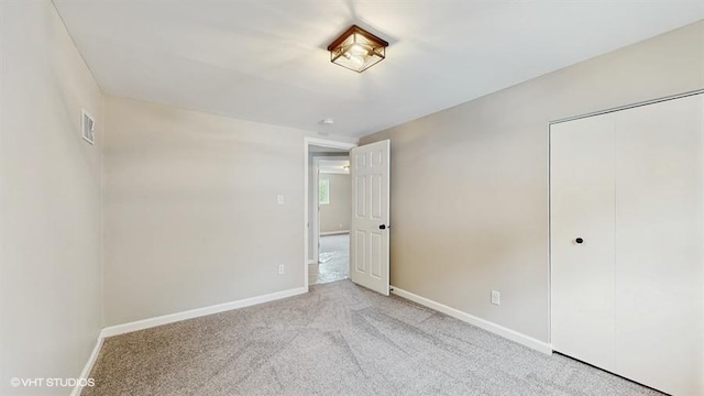 unfurnished bedroom featuring baseboards, carpet flooring, and a closet