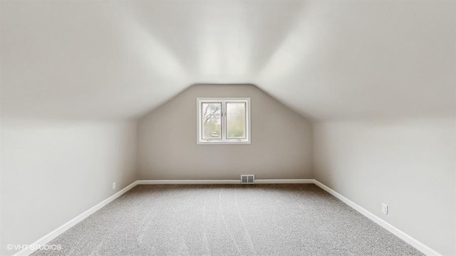 bonus room with carpet floors, baseboards, and lofted ceiling