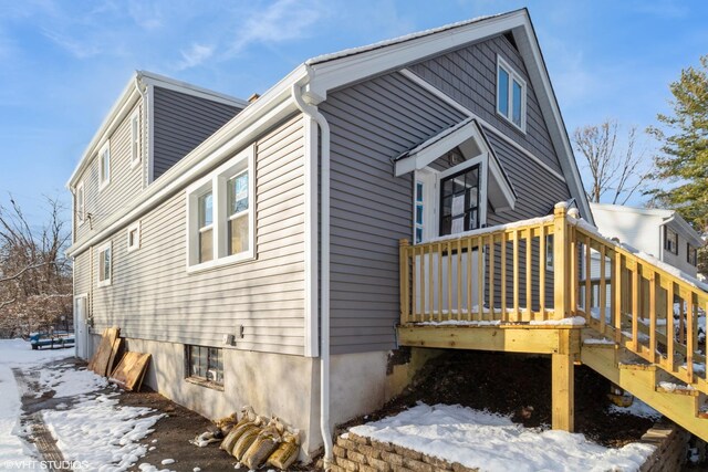 view of snow covered exterior with a deck