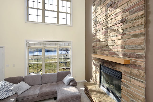 3916 Tallgrass Dr, Champaign, IL 61822 - carpeted living room featuring baseboards, a high ceiling, and a fireplace