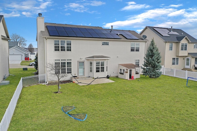 3916 Tallgrass Dr, Champaign, IL 61822 - back of house featuring a fenced backyard, a patio, a yard, and roof mounted solar panels