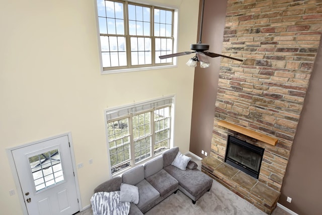 3916 Tallgrass Dr, Champaign, IL 61822 - living area with a healthy amount of sunlight, a high ceiling, a ceiling fan, and a stone fireplace