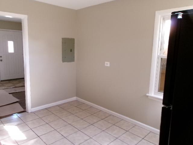 empty room featuring electric panel, baseboards, and light tile patterned flooring