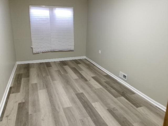 unfurnished room featuring baseboards and wood finished floors