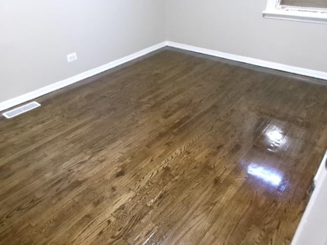 interior space featuring visible vents, baseboards, and dark wood-style flooring