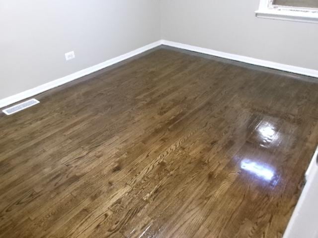 14624 Peoria St, Harvey, IL 60426 - spare room with visible vents, baseboards, and dark wood-style floors