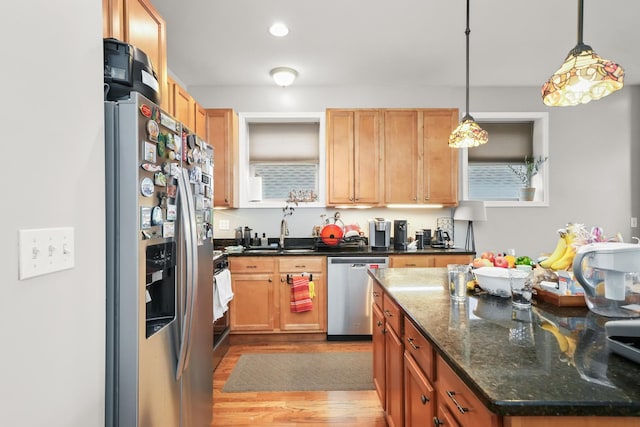 kitchen featuring recessed lighting, a sink, stainless steel appliances, pendant lighting, and light wood-type flooring