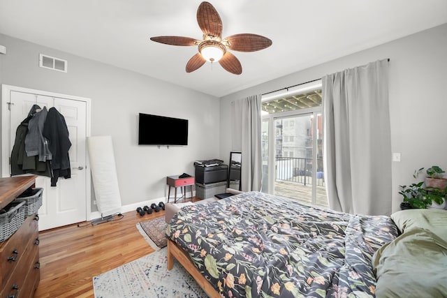 bedroom featuring visible vents, a ceiling fan, access to outside, wood finished floors, and baseboards