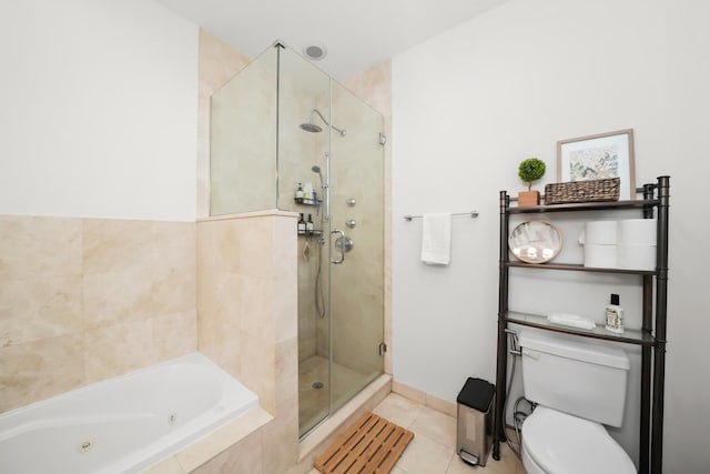 bathroom with tile patterned floors, a tub with jets, a shower stall, and toilet