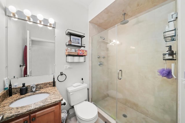 full bathroom featuring toilet, a stall shower, and vanity