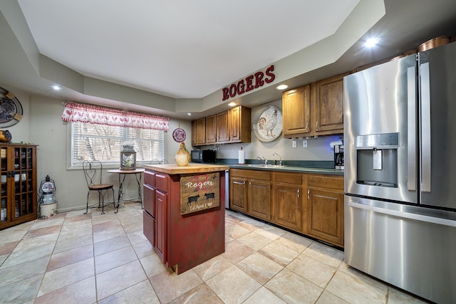 kitchen with a center island, recessed lighting, stainless steel fridge, light tile patterned flooring, and butcher block counters