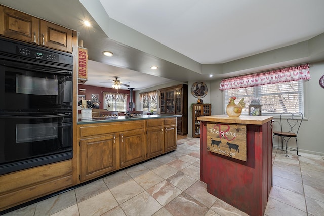 kitchen with a ceiling fan, dobule oven black, wood counters, recessed lighting, and a peninsula