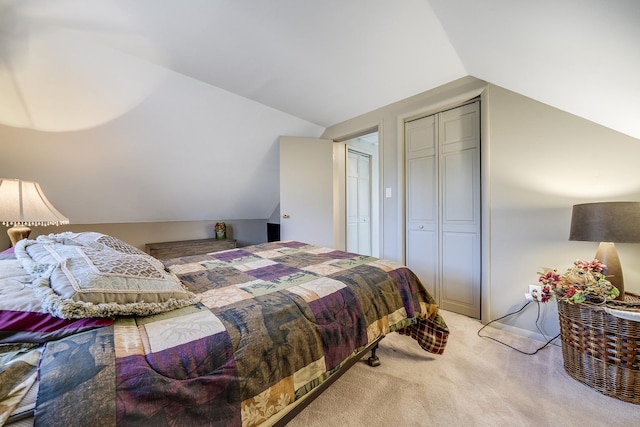 bedroom with a closet, light colored carpet, and vaulted ceiling