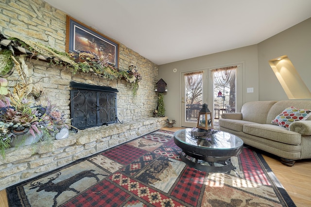 living room with wood finished floors, a fireplace, and french doors