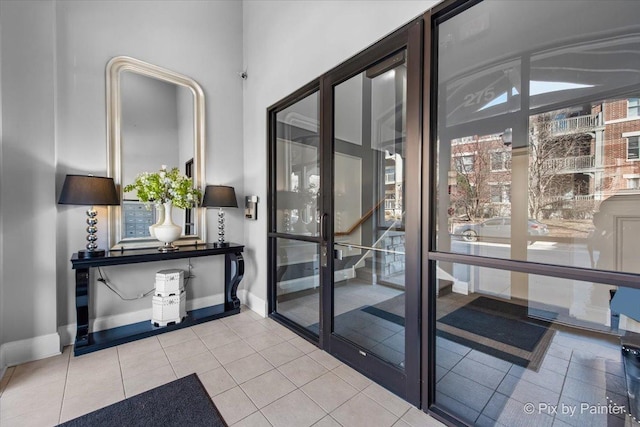 doorway to outside with tile patterned floors and baseboards