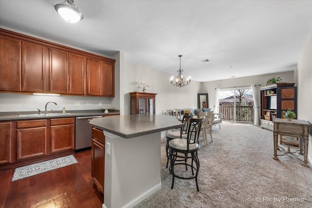 kitchen featuring a kitchen island, a sink, stainless steel dishwasher, open floor plan, and a kitchen bar