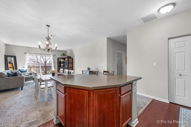 kitchen featuring open floor plan, a notable chandelier, visible vents, and a kitchen island