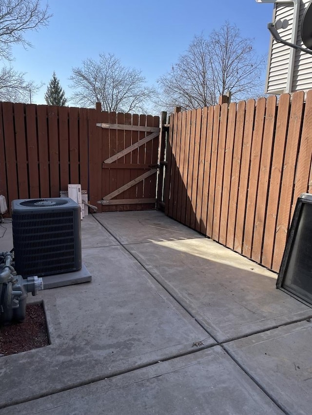 view of patio / terrace with central AC unit, fence, and a gate