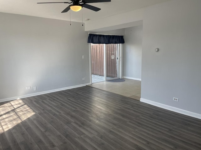 empty room featuring baseboards, wood finished floors, and ceiling fan