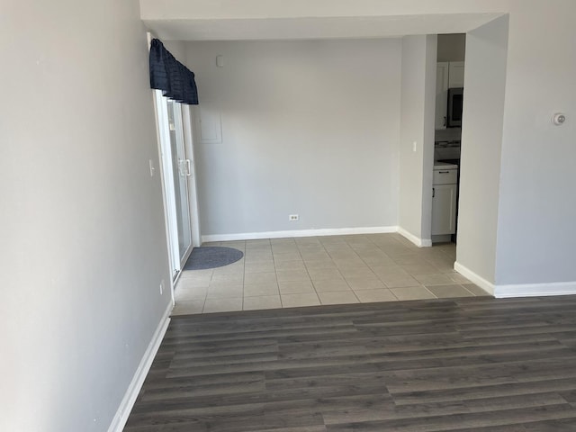 unfurnished room featuring tile patterned floors and baseboards