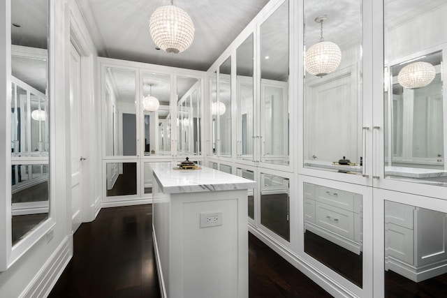 spacious closet featuring an inviting chandelier and dark wood-style floors