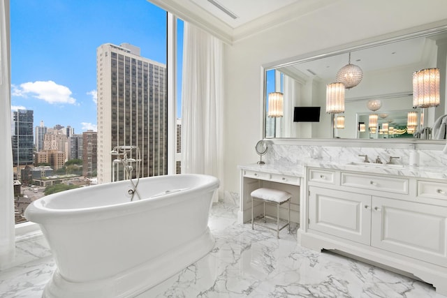 bathroom with vanity, crown molding, a freestanding tub, and marble finish floor