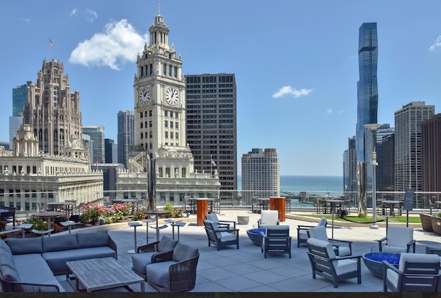 view of patio / terrace featuring a city view, a water view, and an outdoor hangout area