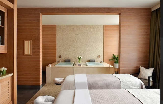 bathroom featuring a bathtub and wood walls