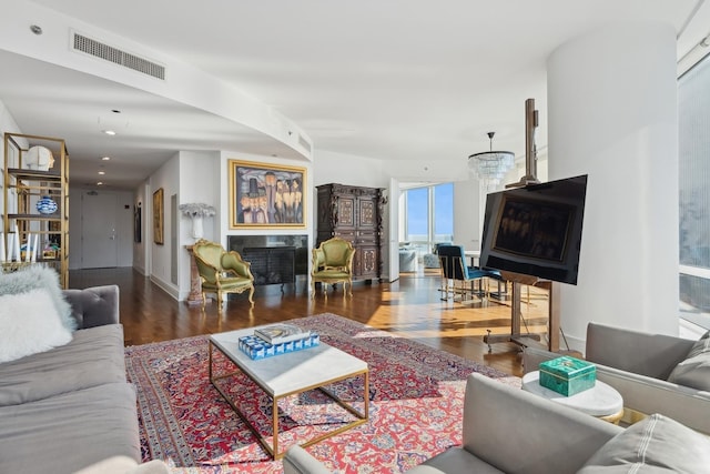 living area featuring visible vents, baseboards, wood finished floors, and a fireplace