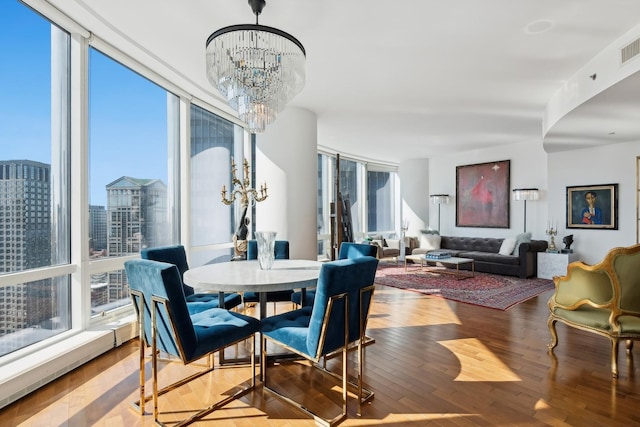 dining space featuring a wall of windows, wood finished floors, a wealth of natural light, and a chandelier