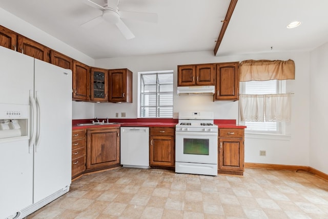 kitchen with white appliances, baseboards, a sink, ceiling fan, and under cabinet range hood