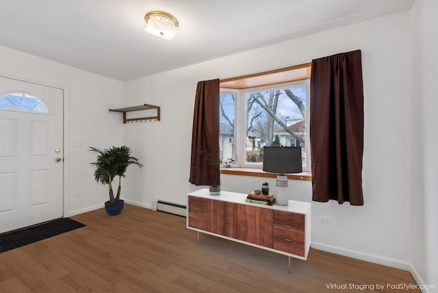 entrance foyer featuring a baseboard heating unit, baseboards, and wood finished floors