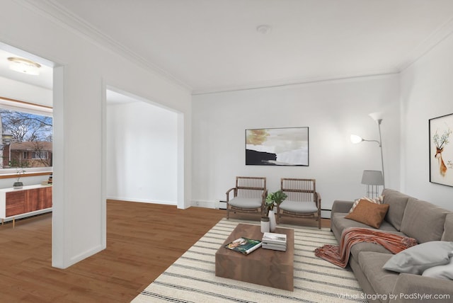 living area with baseboards, wood finished floors, ornamental molding, and a baseboard radiator