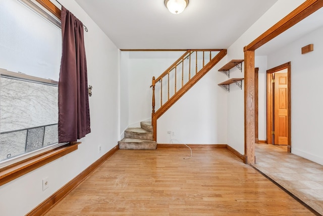 entrance foyer featuring light wood finished floors, stairs, and baseboards