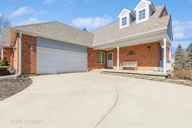 view of front facade featuring brick siding, driveway, a garage, and roof with shingles