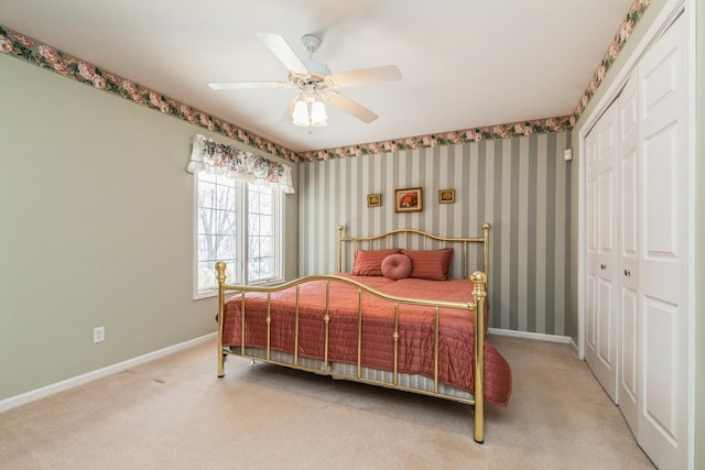 bedroom featuring wallpapered walls, baseboards, and a closet