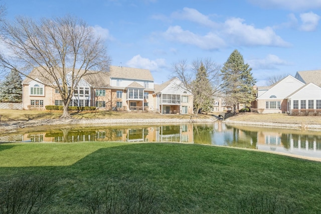 rear view of property featuring a yard and a water view