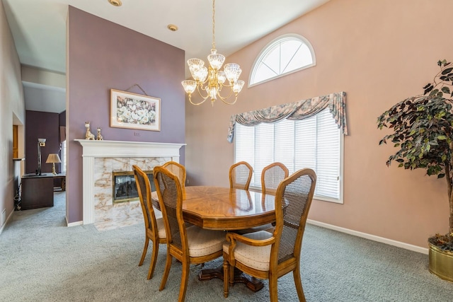 dining area with a notable chandelier, carpet flooring, baseboards, and a high end fireplace