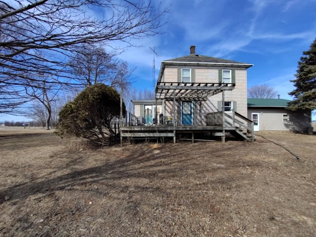 rear view of property with a wooden deck, a chimney, and a pergola